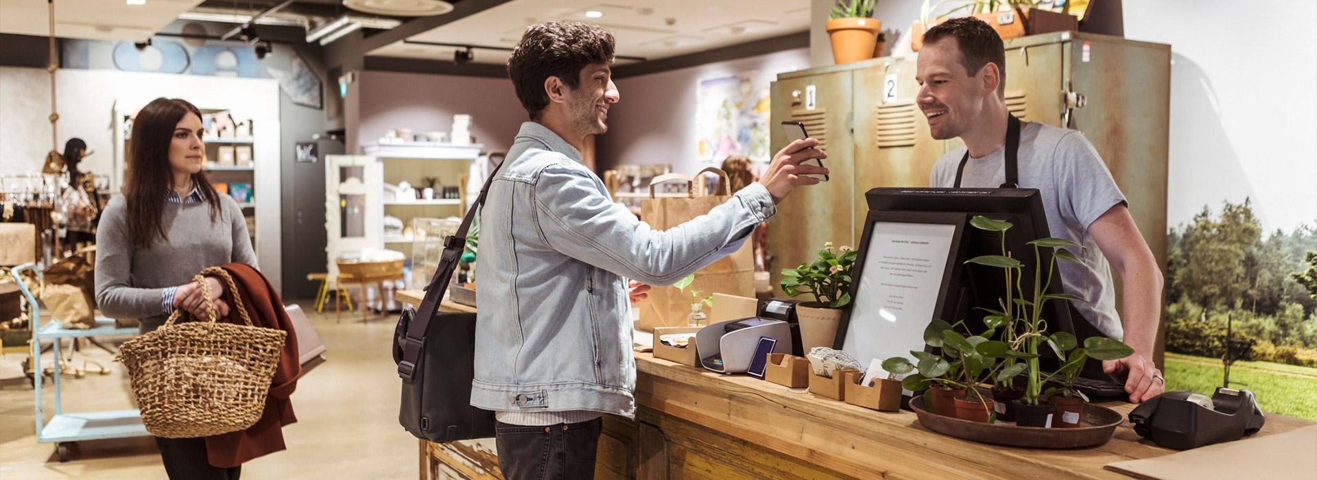 man showing cellphone to cashier