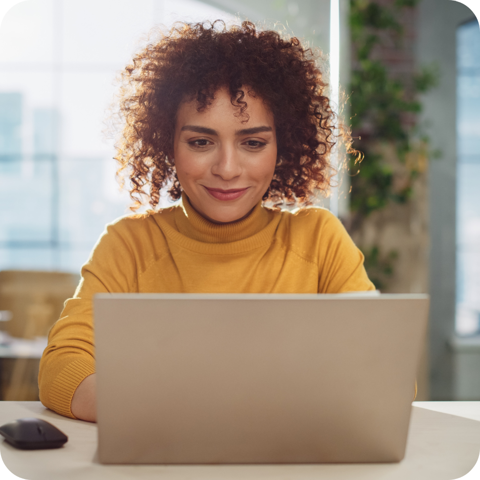 Woman on laptop in yellow top